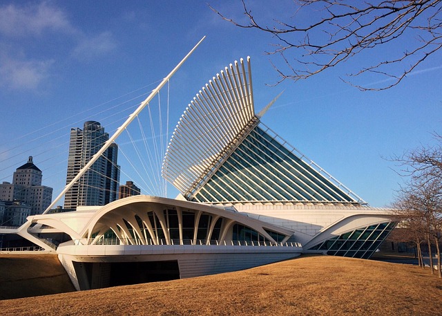 Photograph of Milwaukee Art Museum showcasing its modern architectural design with white, wing-like structures and glass panels under a clear blue sky. 