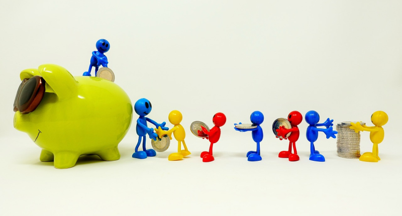 Small coloured figures pass pound coins from a stack down the line, working as a team, towards a green piggy bank with sunglasses. One of the figures is on top of the piggy bank, putting a pound coin through the slot. 